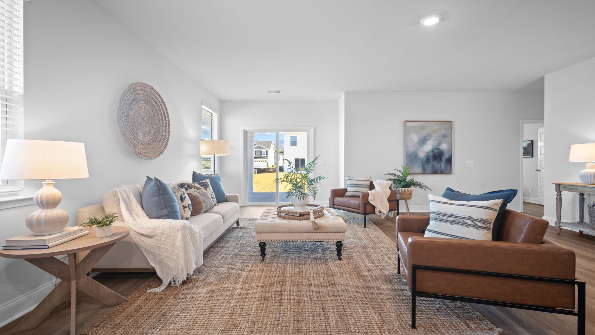 Alternate angle of the living room showing seating and windows.