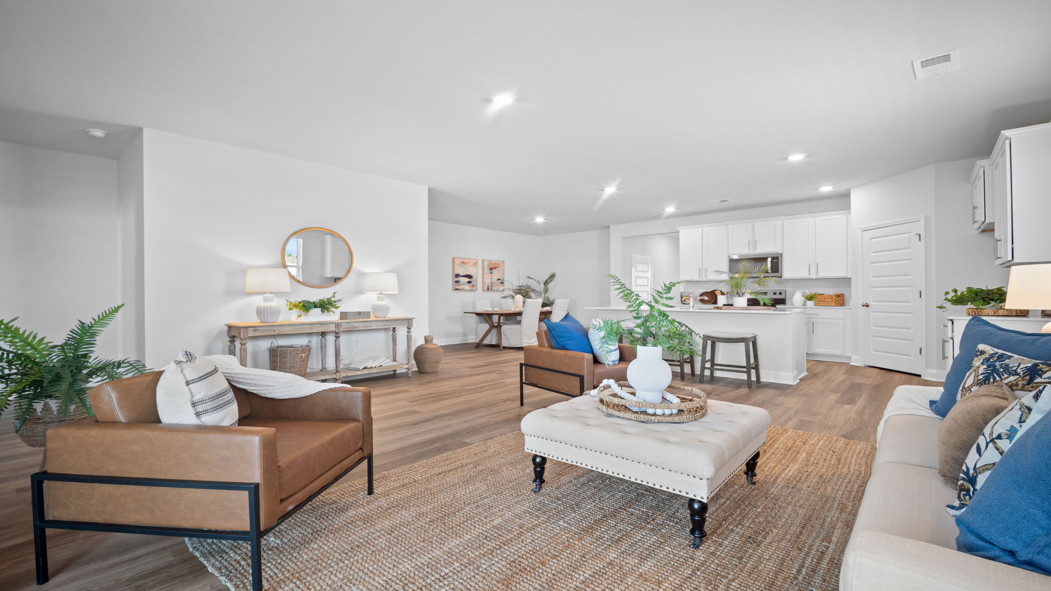 Living room with seating area and windows providing natural light.