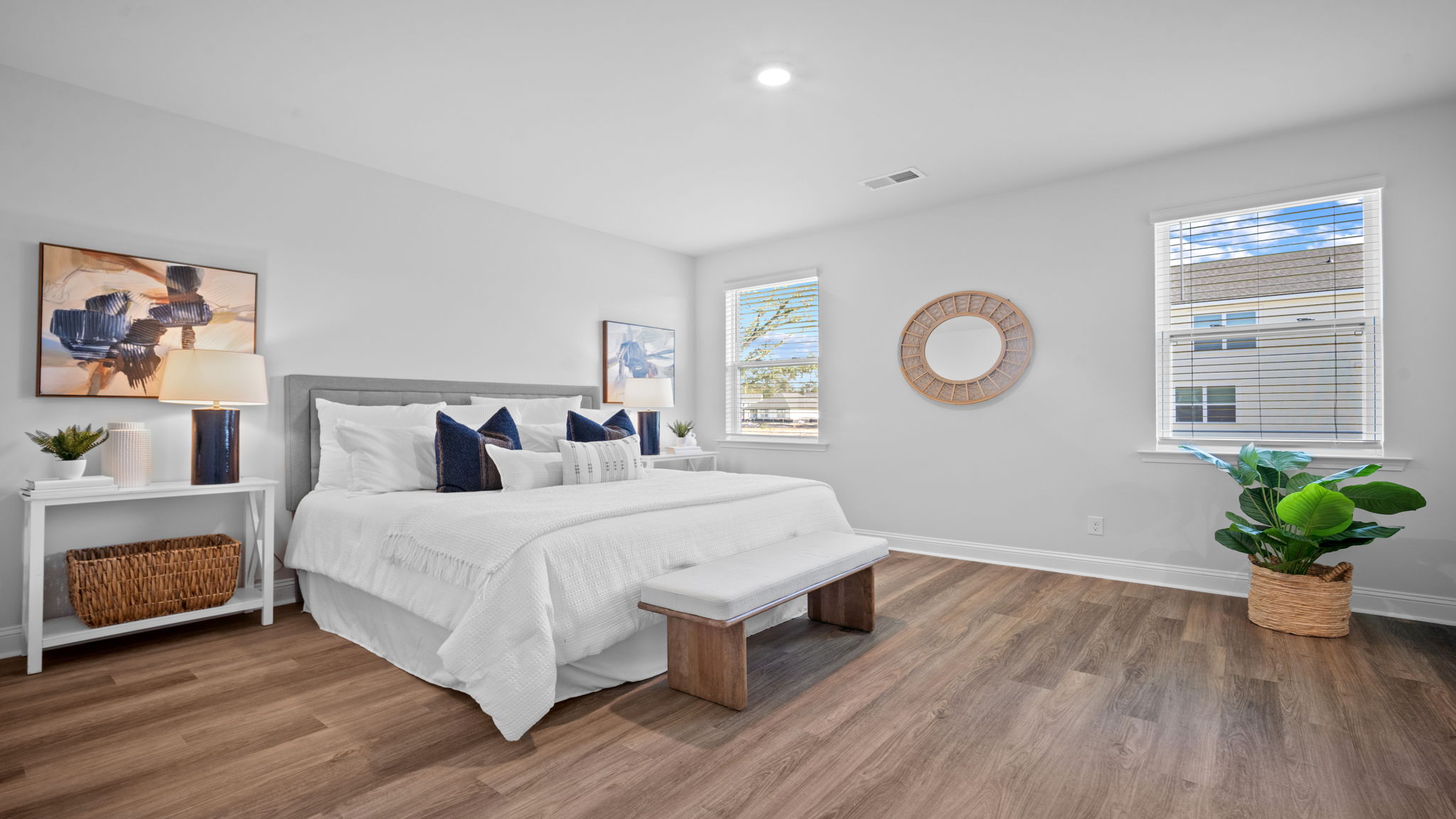 Primary bedroom with bed and natural light from windows.