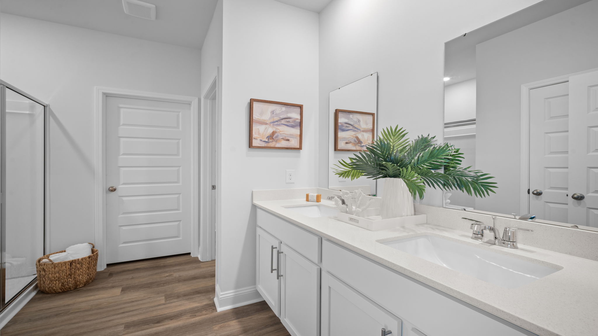 Primary bathroom with double vanity and shower area.