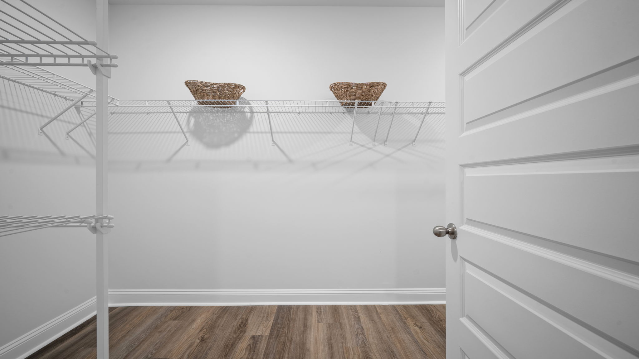 Primary walk-in closet with shelving and hanging space.