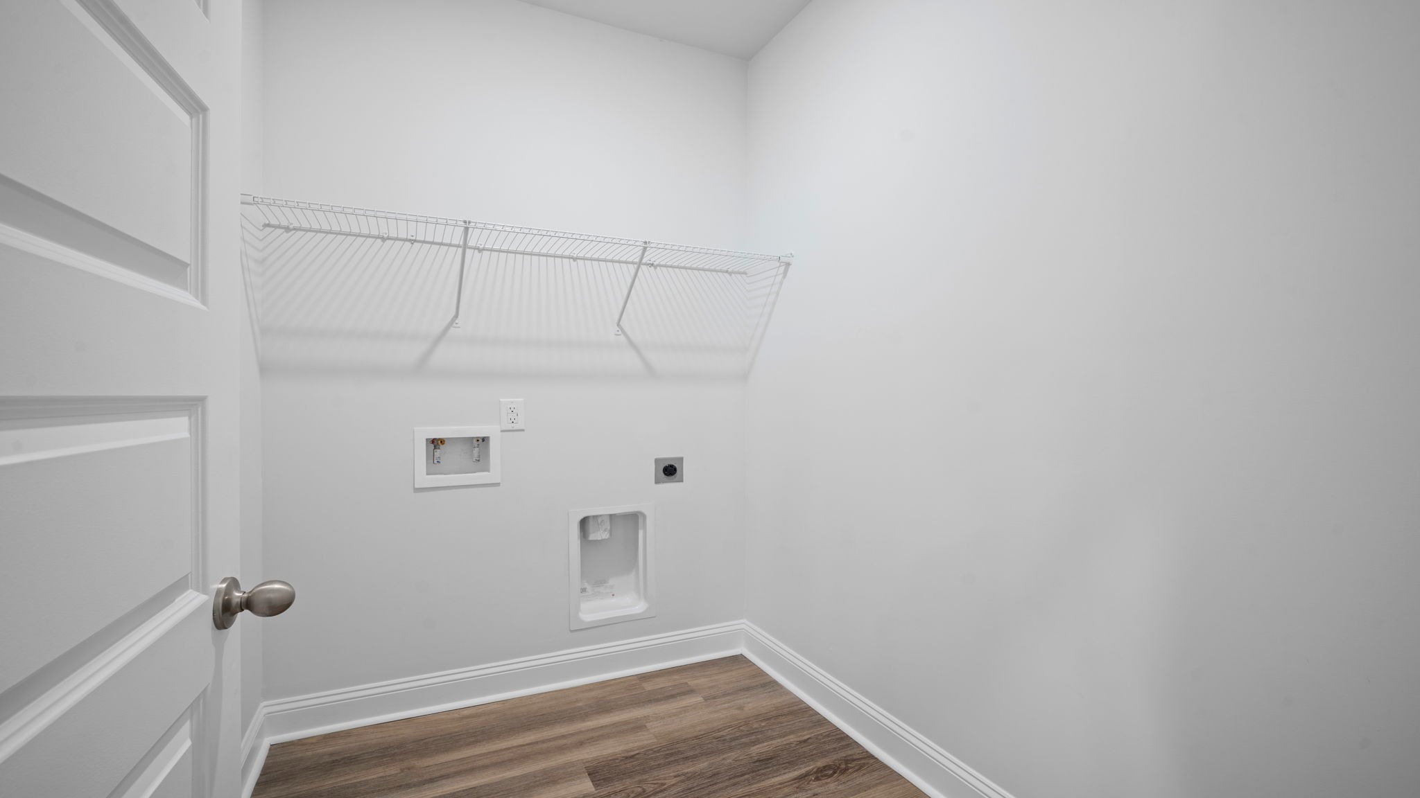 Spacious laundry area has room for a washer and dryer with built in shelves.