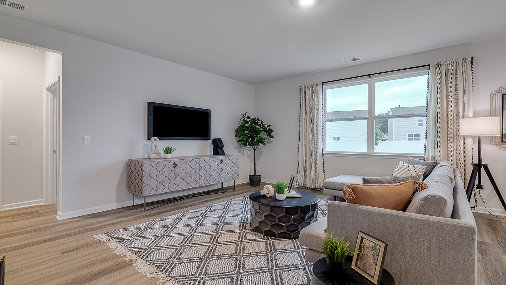 Open living room in DR Horton Hayden model with natural light, spacious layout, and connection to kitchen and dining space