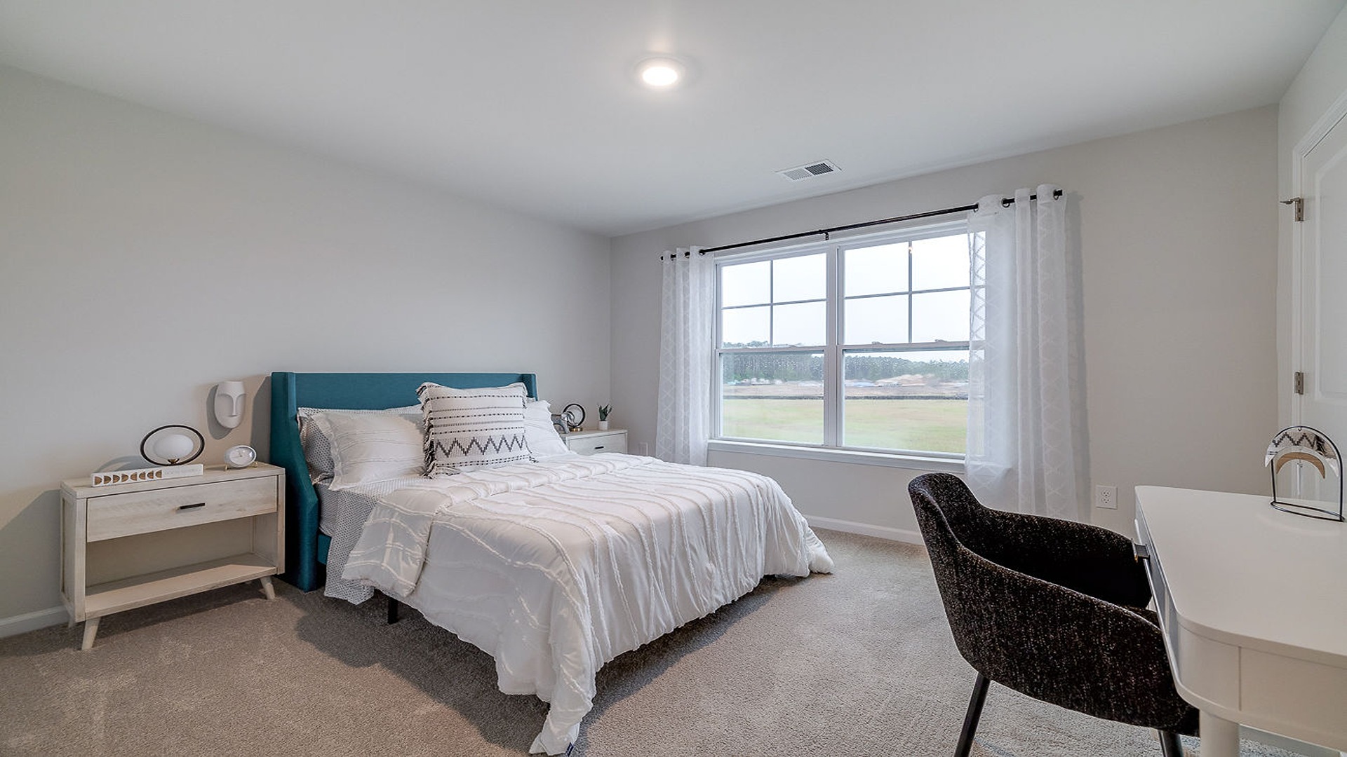 Spacious guest bedroom in DR Horton Hayden home featuring natural light, neutral finishes, and flexible layout