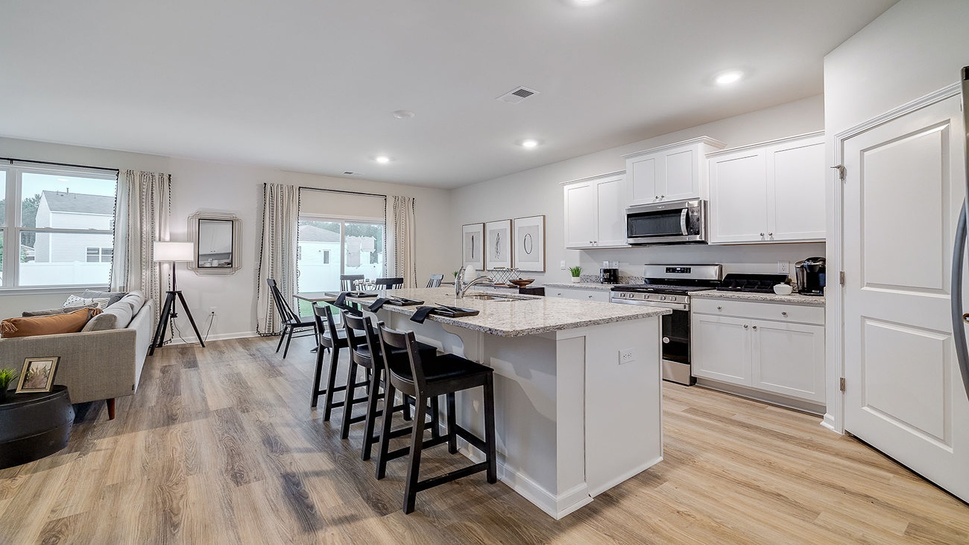 Open-concept kitchen in Hayden floor plan with large center island, stainless steel appliances, and seamless flow into dining and living areas