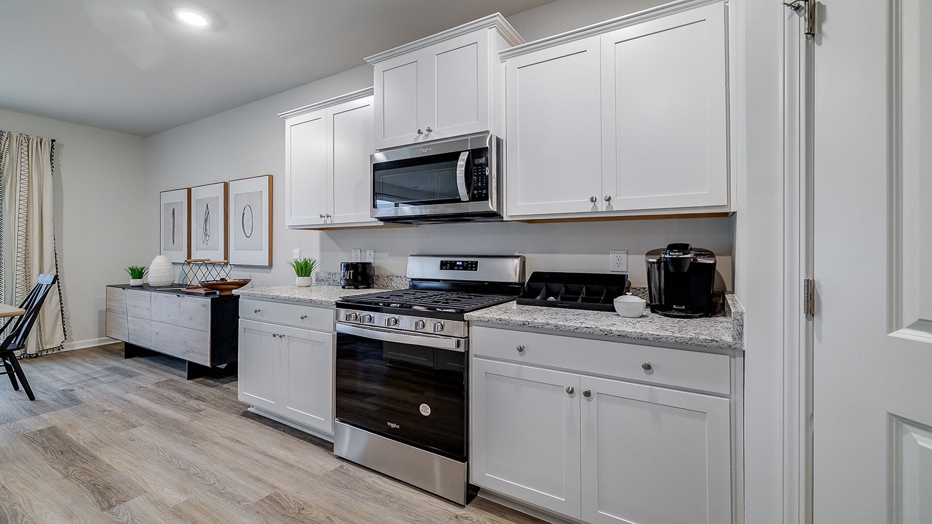 Chef-inspired kitchen in Hayden model home with pendant lighting, ample counter space, and open-concept family room connection