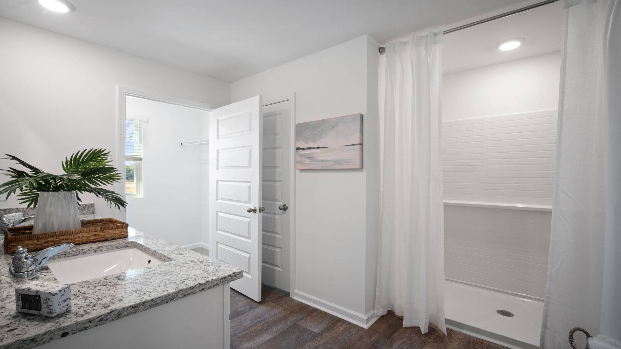 Spa-like primary bathroom in the Hayden floor plan at Laurel Grove by D.R. Horton featuring dual vanities, a walk-in shower, modern fixtures, and designer-selected finishes for everyday luxury.
