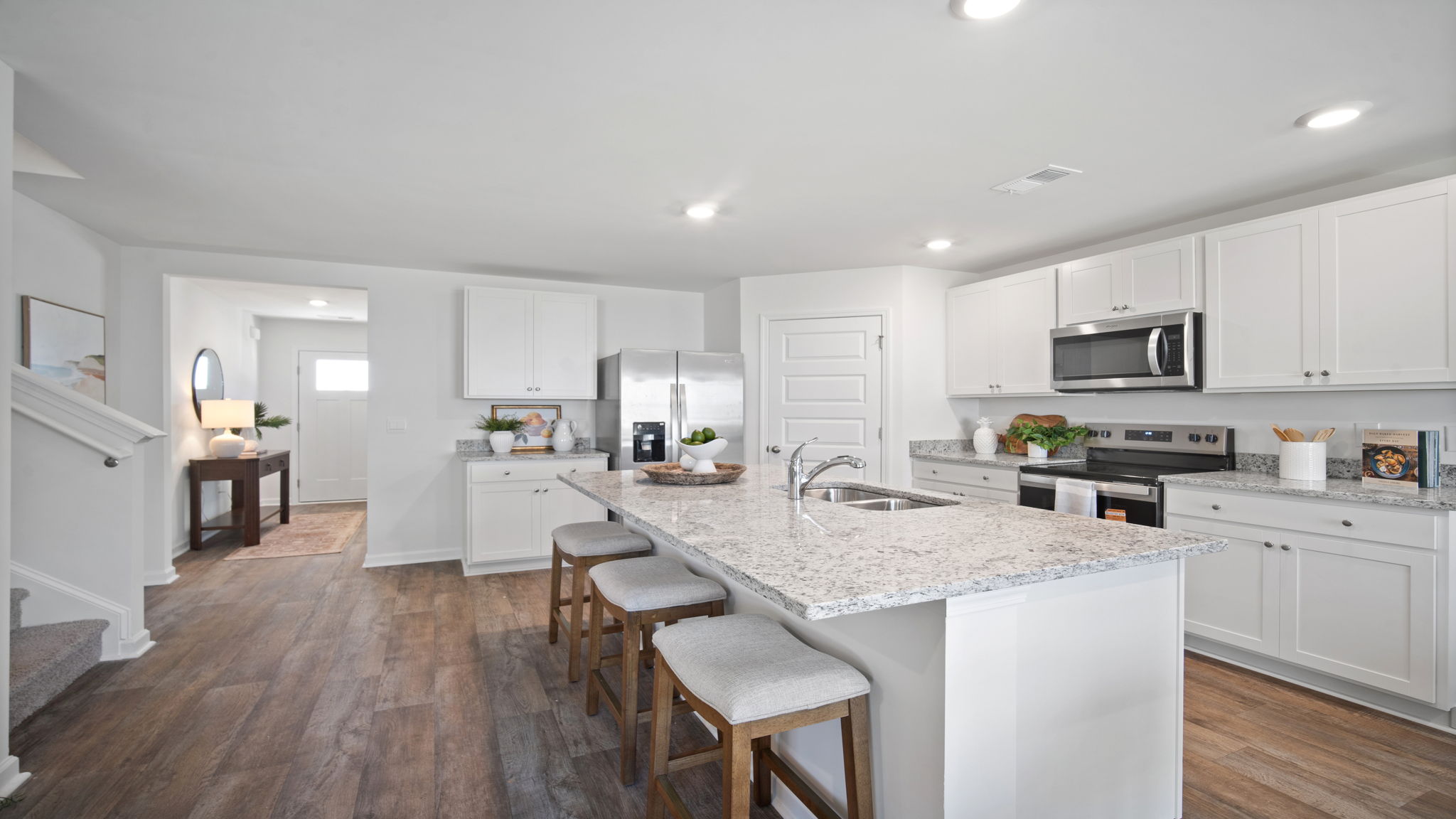 Expansive kitchen island in the Hayden floor plan at Laurel Grove by D.R. Horton featuring ample seating, granite countertops, abundant prep space, and an open-concept design that serves as the centerpiece for entertaining and everyday living.