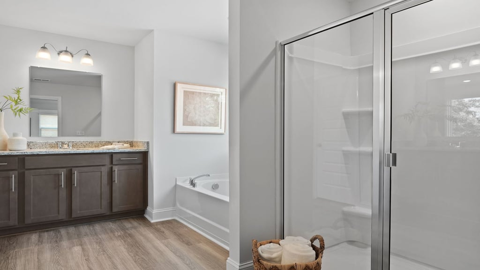 primary bathroom with soaking tub and light-fixtures over vanity