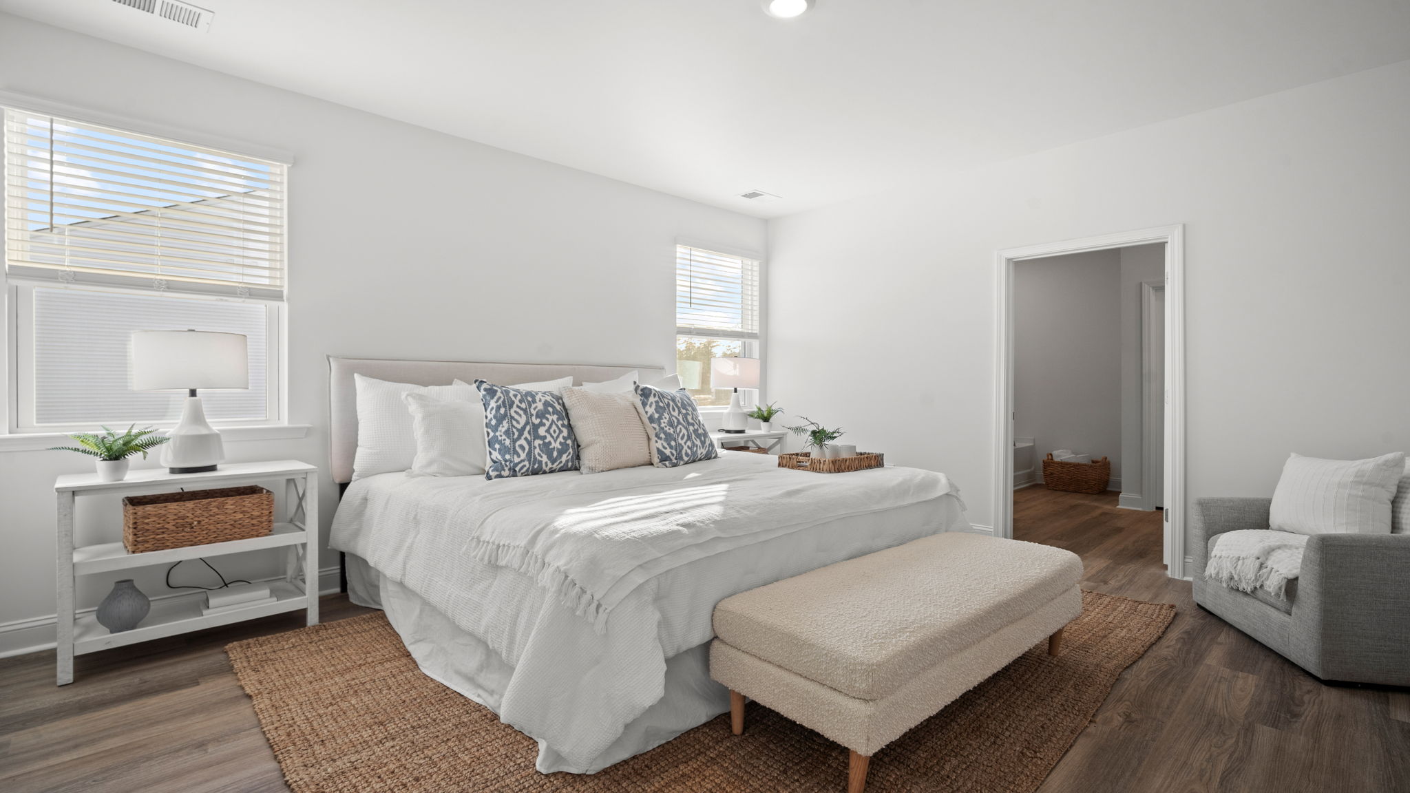 Primary bedroom decorated with a bed, bench and side table