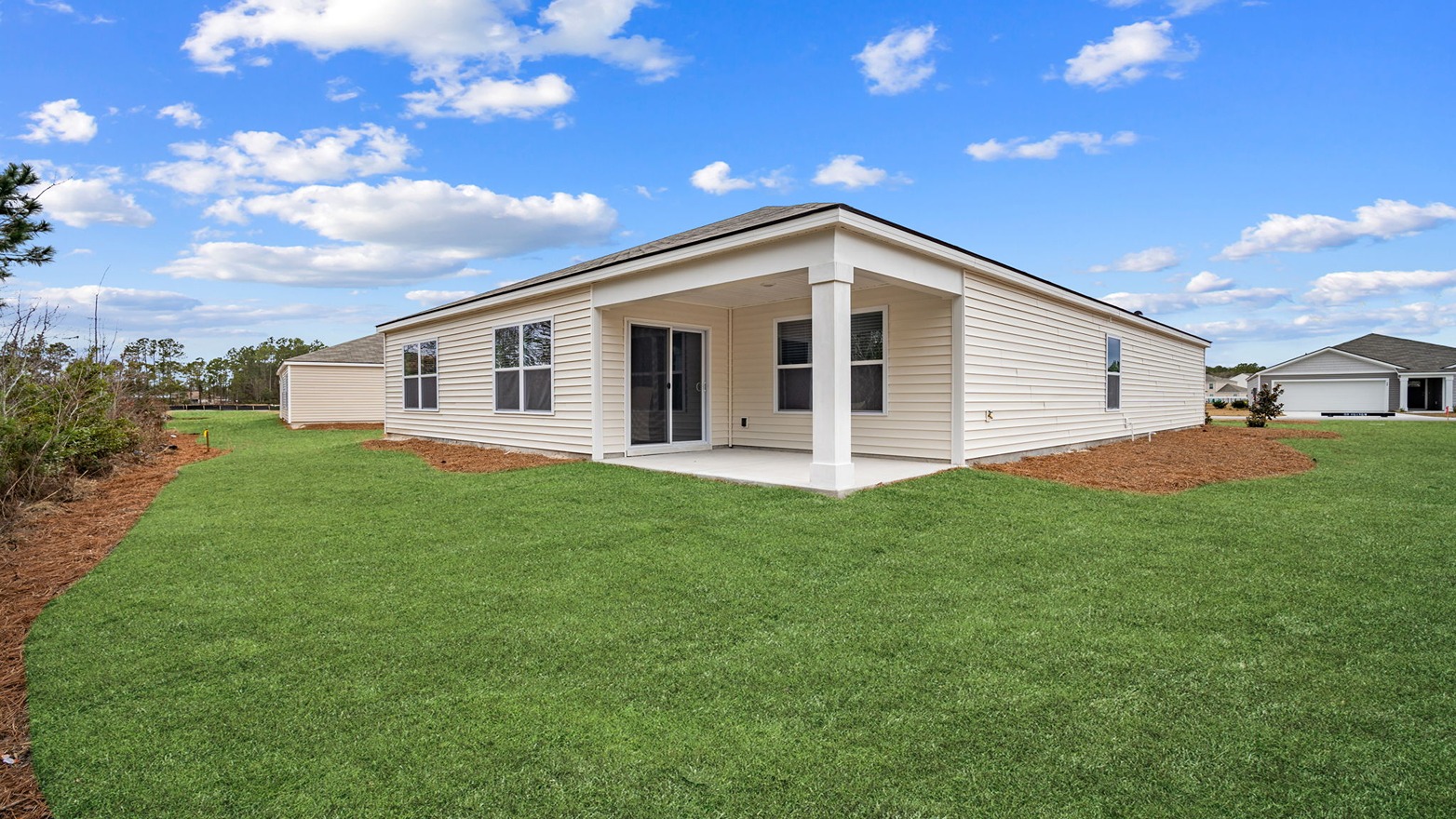 The covered back patio opens to greenspace.