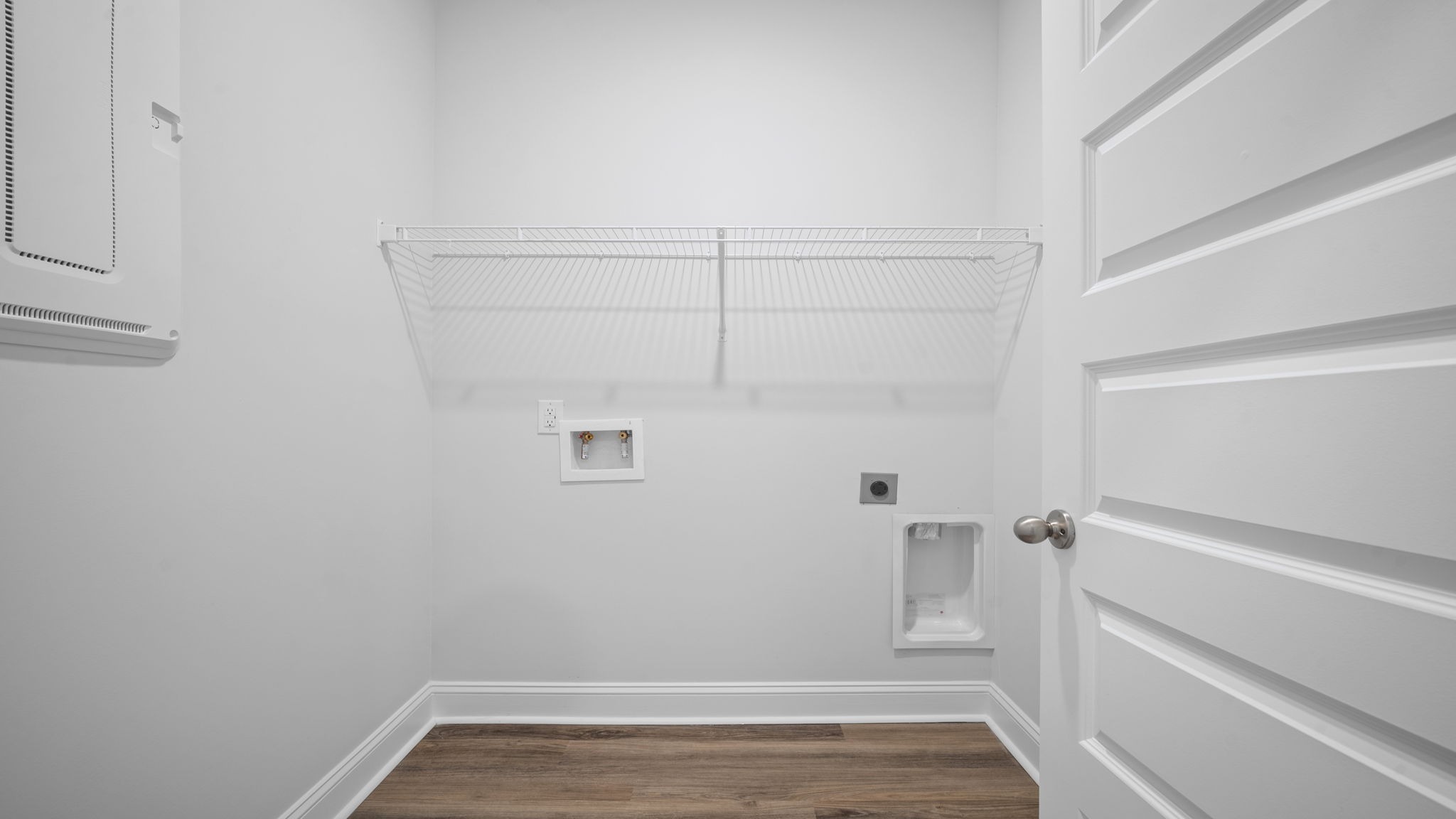 Spacious laundry area has room for a washer and dryer with built in shelves.