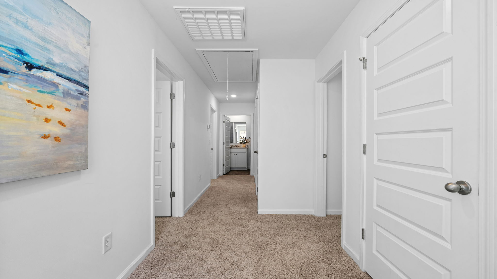 Second-floor hallway leading to bedrooms, bathrooms, and laundry space.
