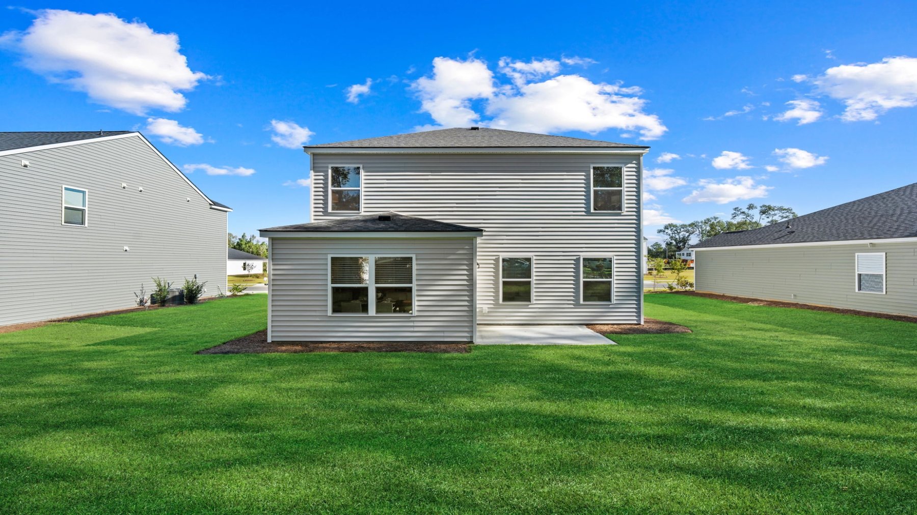 Wide view of the backyard and rear elevation with covered outdoor living space.