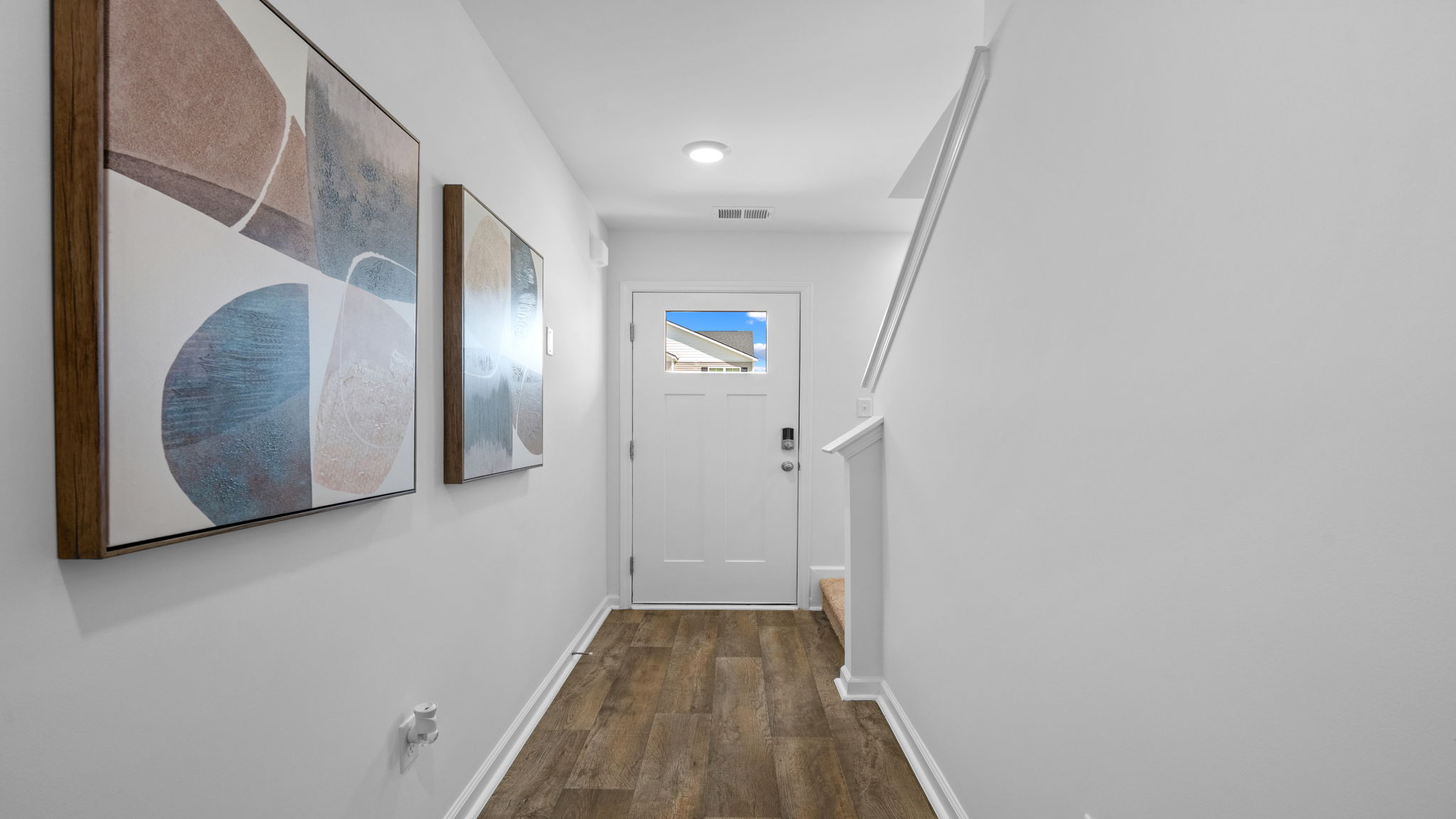 Hallway inside the Darwin floorplan featuring modern flooring, neutral walls, and access to main living areas