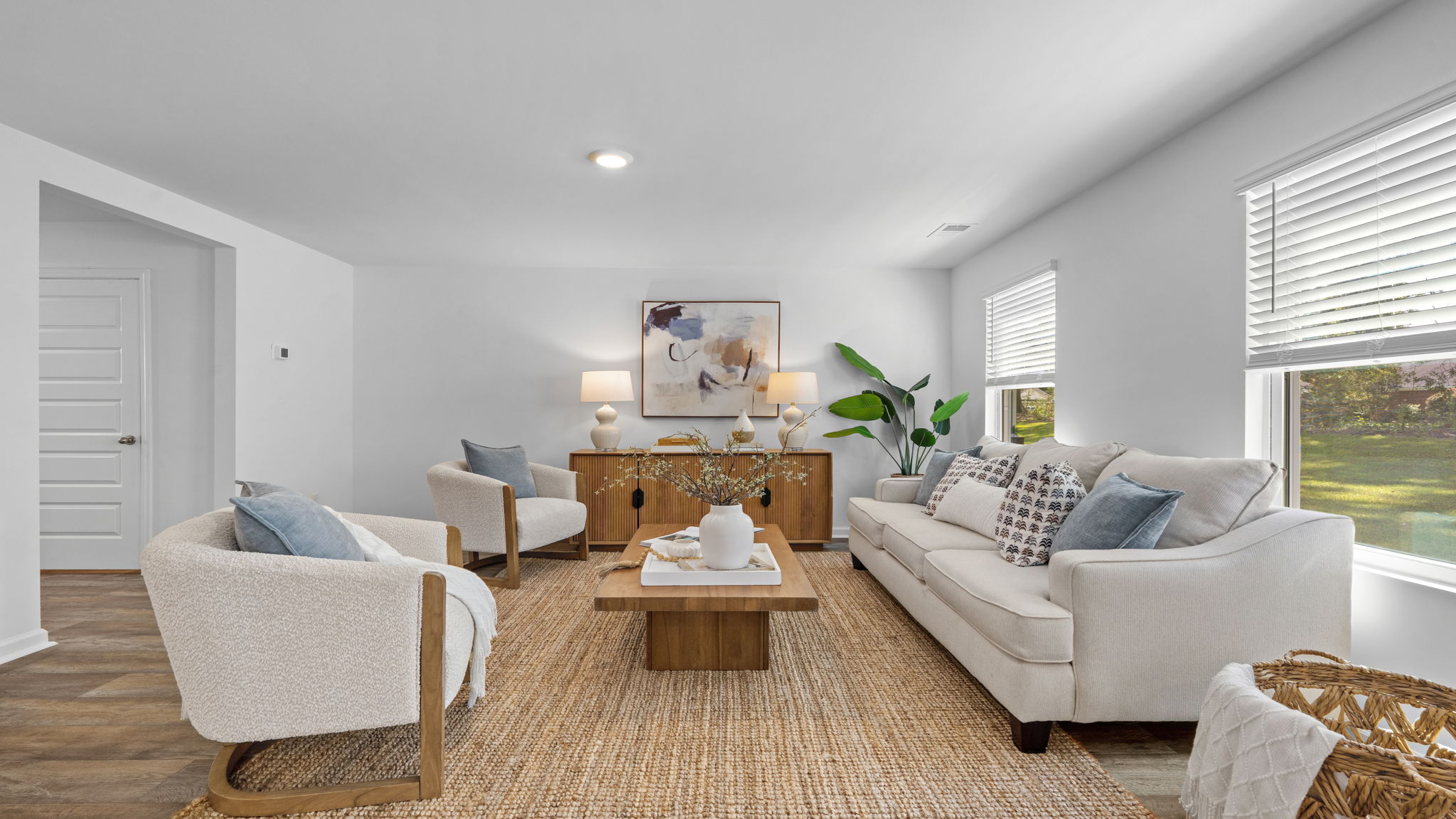 Bright living area with large window, plush furnishings, and open view of the main living space.