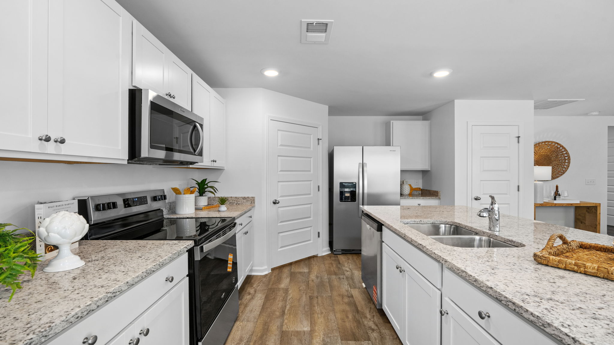 Kitchen in the Darwin floorplan showcasing granite countertops, stainless steel appliances, and generous storage.
