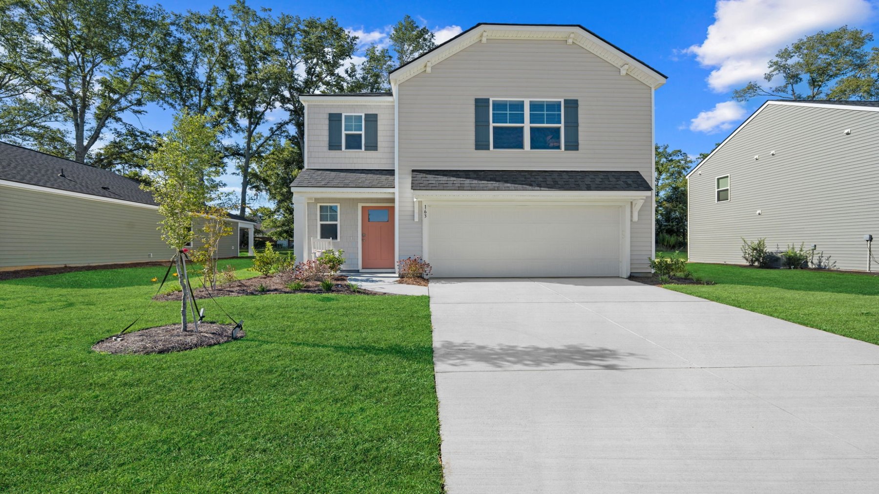 Front exterior of the Darwin home in Stockyard showcasing a two-story design, attached two-car garage, driveway, and landscaped yard.