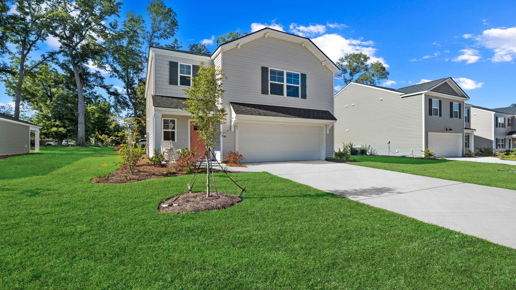 Front exterior perspective of the Darwin home highlighting the attached garage, landscaped entry, and large homesite