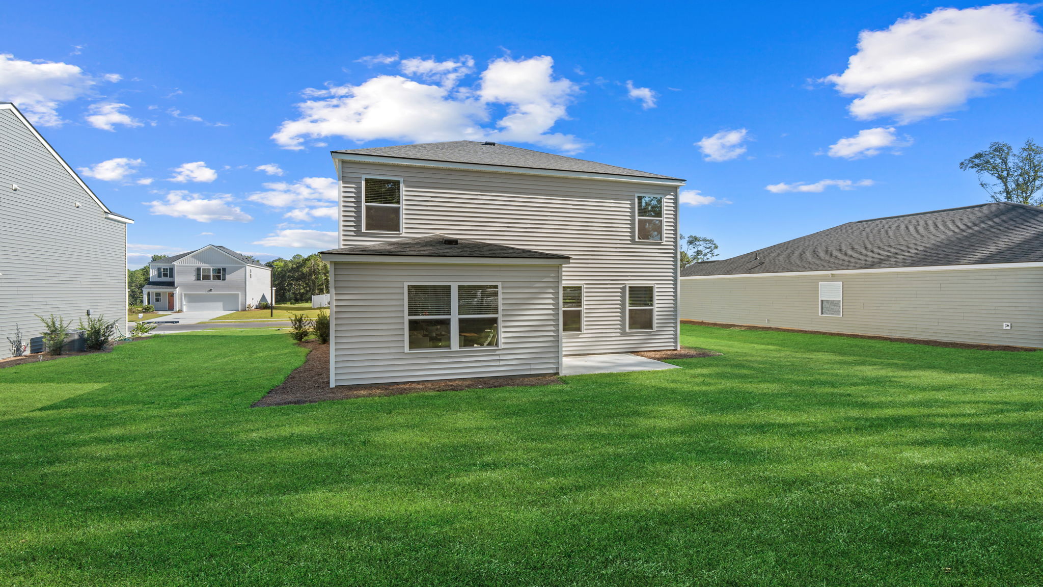 Rear exterior view of the Darwin home in Stockyard featuring a spacious backyard, covered patio, and two-story design.