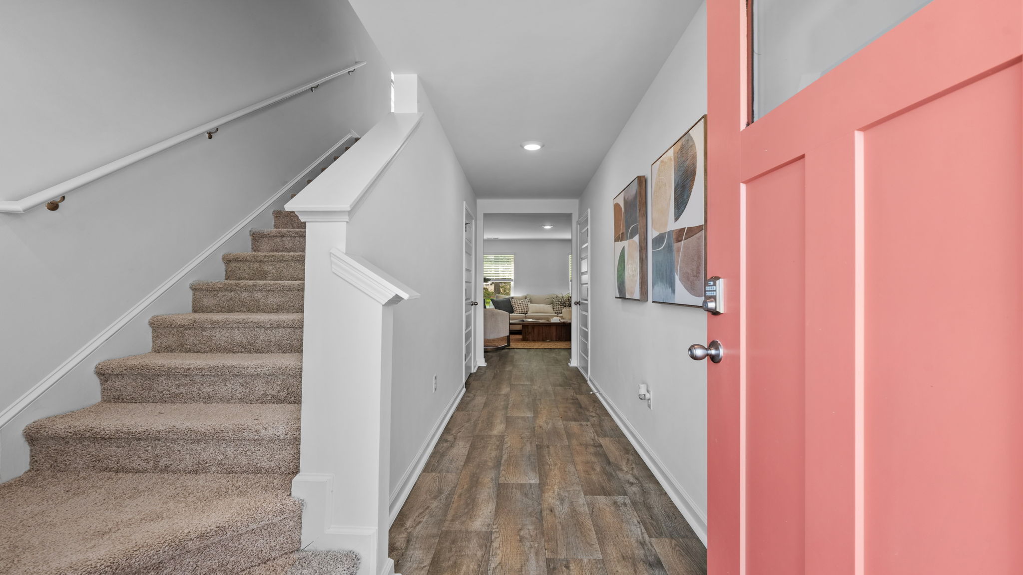 Foyer entry of the Darwin home showcasing staircase, luxury vinyl plank flooring, and bright interior finishes
