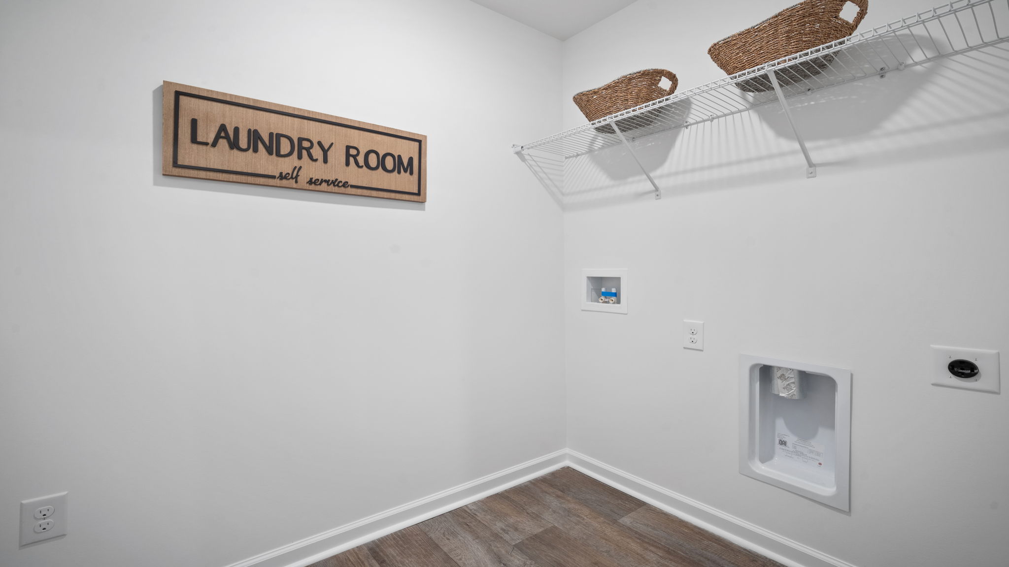 Spacious laundry area has room for a washer and dryer with built in shelves.