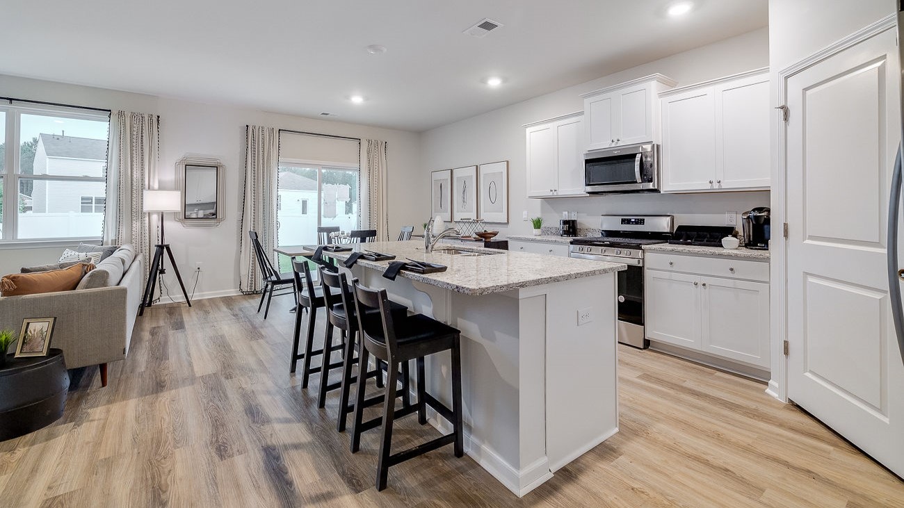 Modern kitchen in Hayden floor plan featuring large center island, granite countertops, and open layout for entertaining.