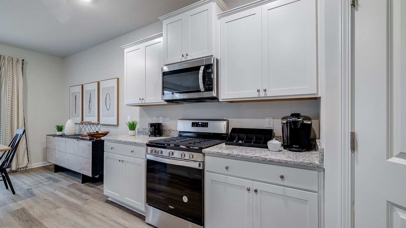 Chef-inspired kitchen with stainless steel appliances, ample cabinetry, and spacious island in DR Horton Hayden Stockyard