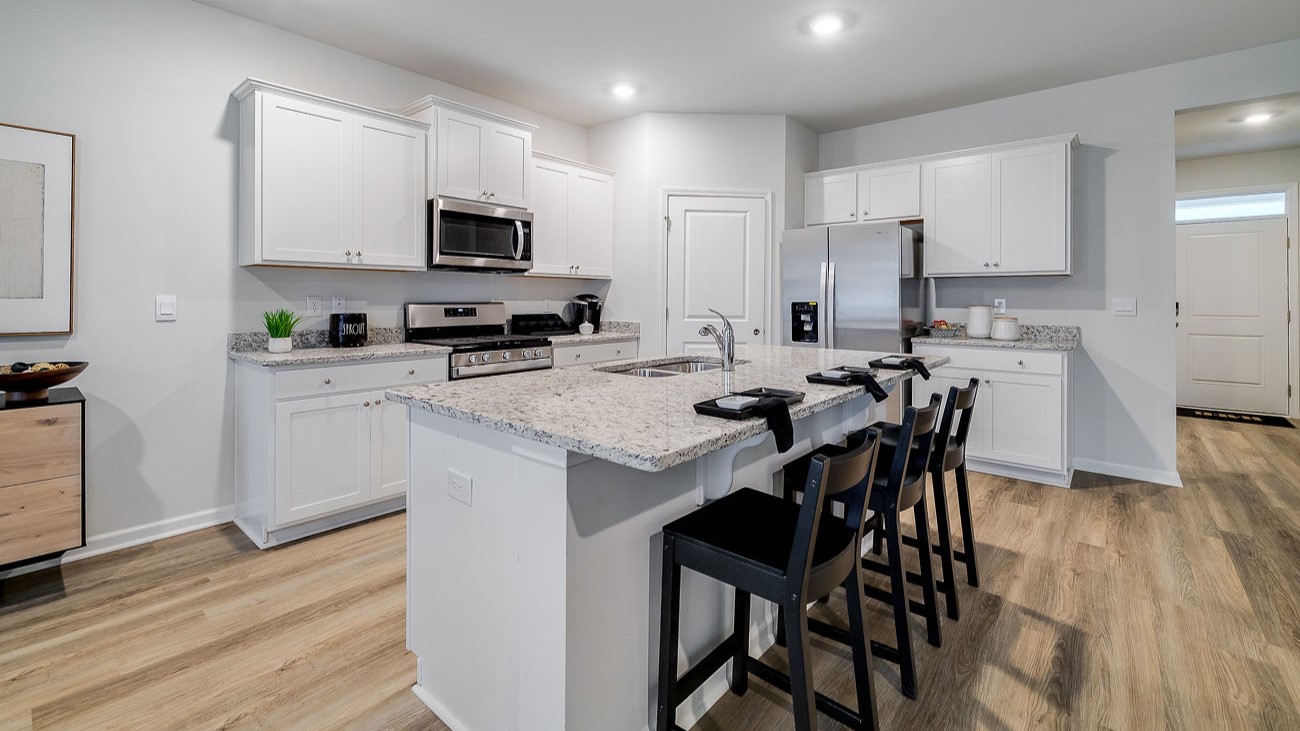 Chef-inspired kitchen with stainless steel appliances, ample cabinetry, and spacious island in DR Horton Hayden Stockyard