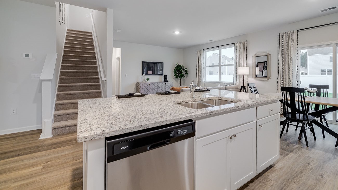 Modern kitchen in Hayden floor plan featuring large center island, granite countertops, and open layout for entertaining.