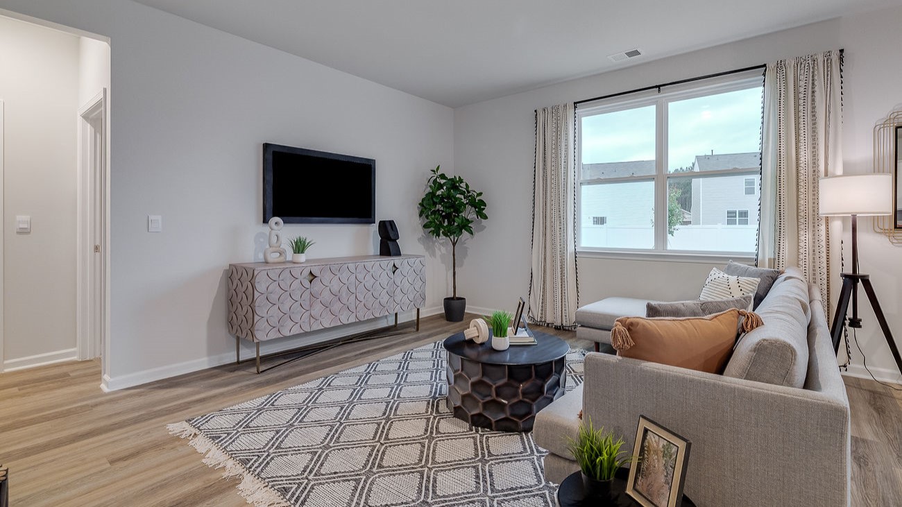 Open concept living room in Hayden DR Horton home connected to kitchen and dining space, ideal for entertaining and family living.