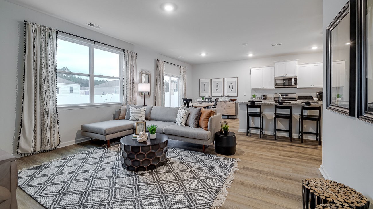 Open concept living room in Hayden DR Horton home connected to kitchen and dining space, ideal for entertaining and family living.