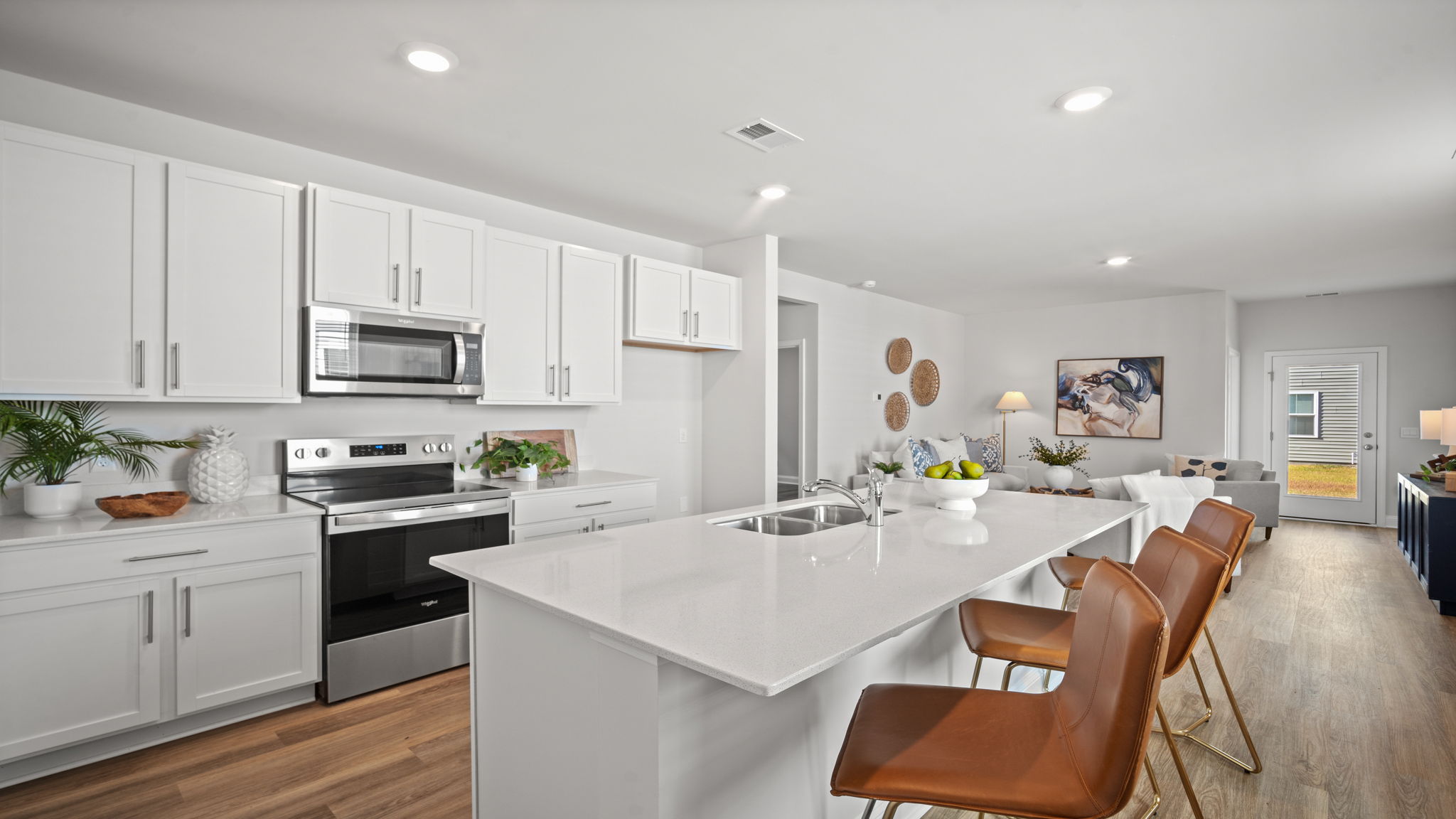 Gourmet kitchen featuring oversized island, stainless steel appliances, walk-in pantry, and abundant cabinet storage.