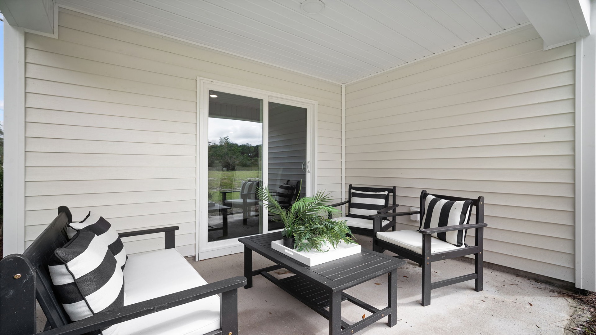 Rear covered patio decorated with seating and a table