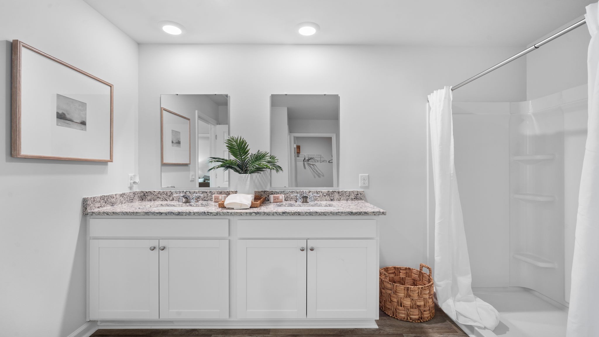 Elegant primary en-suite bath in the Cali home with ample counter space, bright lighting, and convenient access to the walk-in closet.