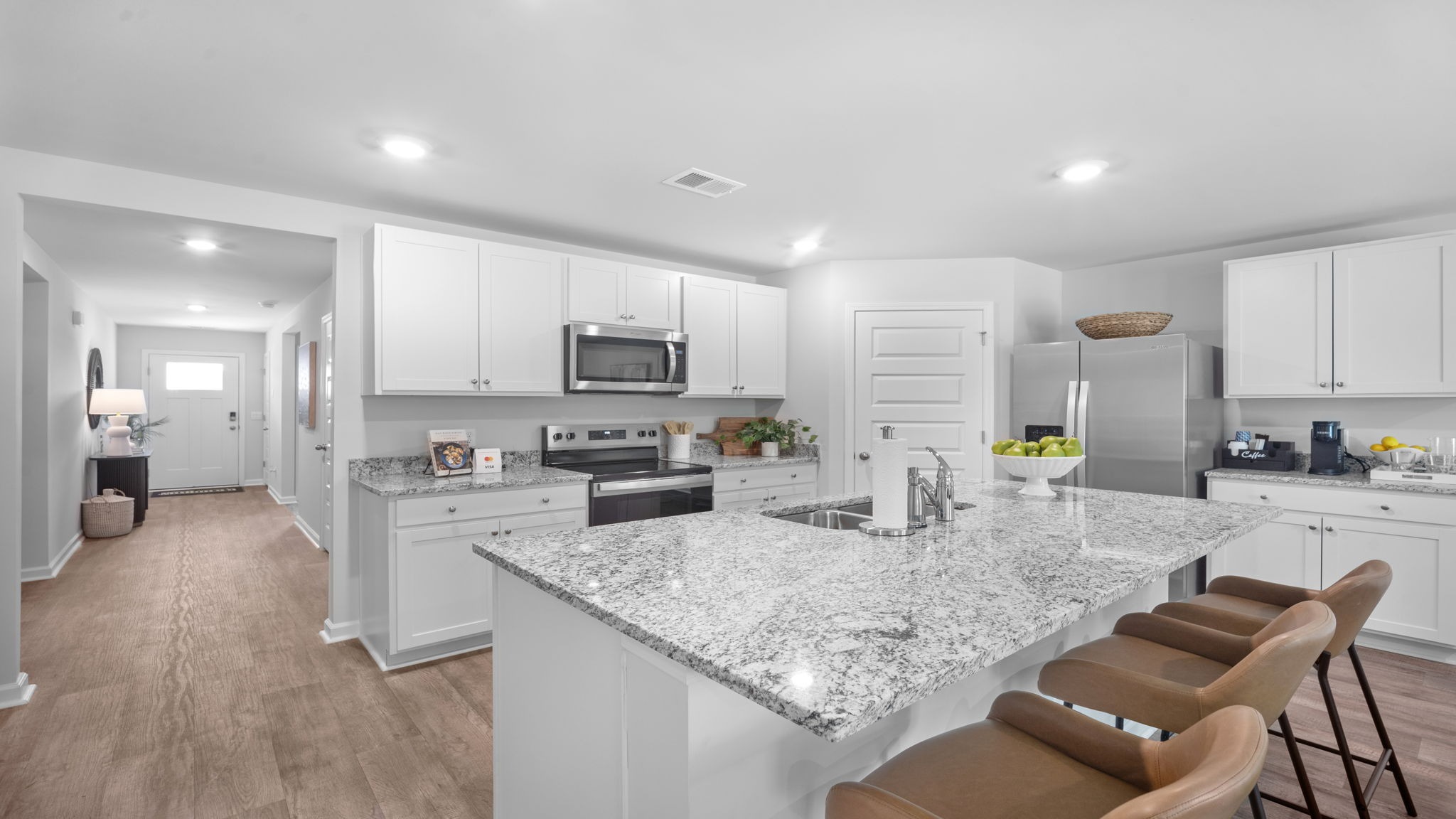 Bright Cali kitchen with abundant cabinet storage, spacious island seating, and uninterrupted views of the dining and family room.