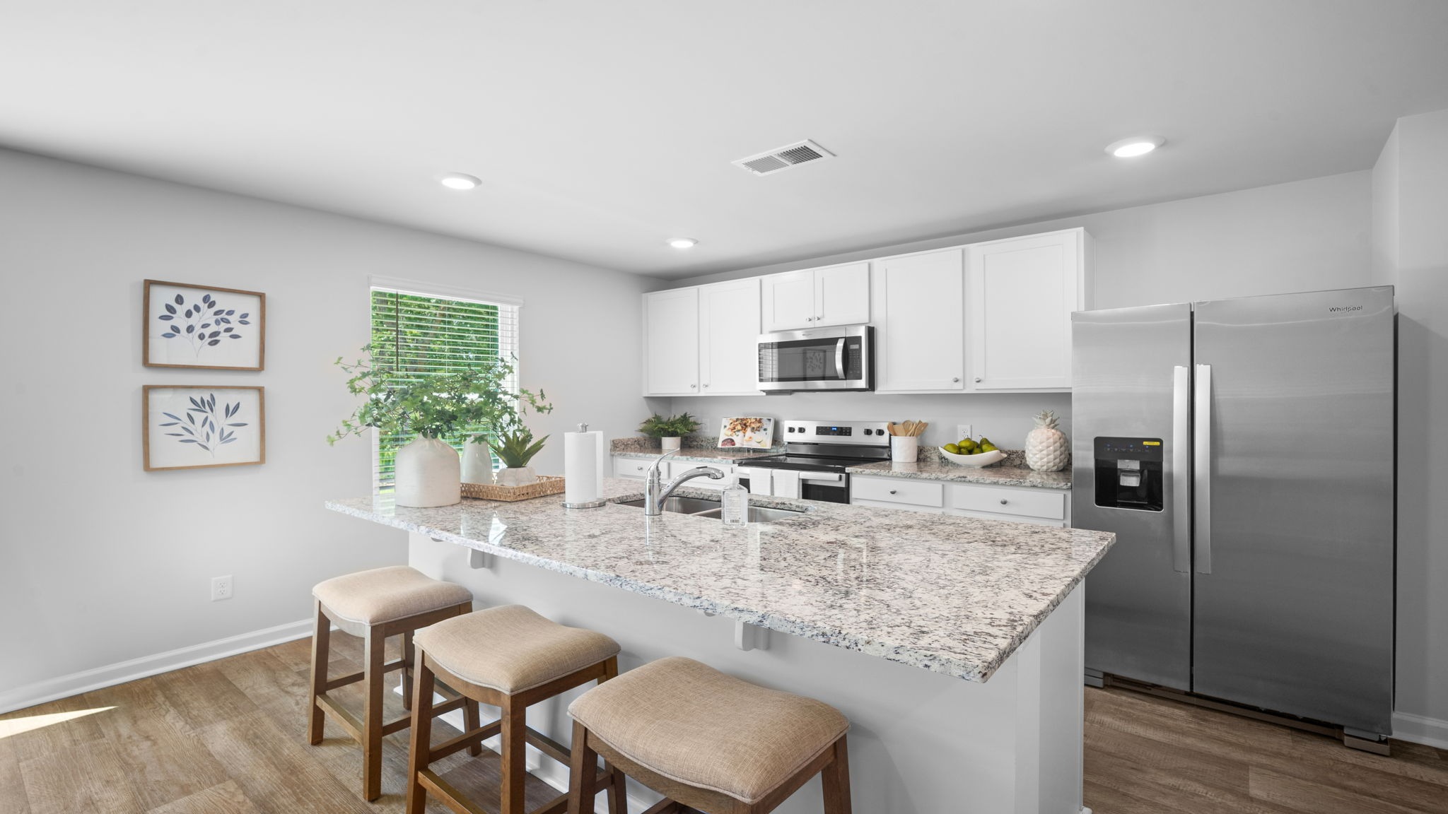 Open-concept kitchen in the Belhaven floor plan featuring granite countertops, stainless steel appliances, center island, and abundant cabinet storage.