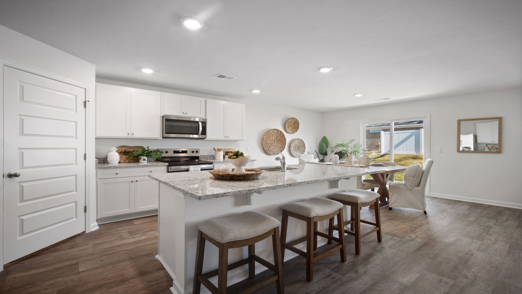 Open-concept kitchen in the Hayden floor plan featuring a large center island, granite countertops, stainless steel appliances, and abundant cabinet storage.