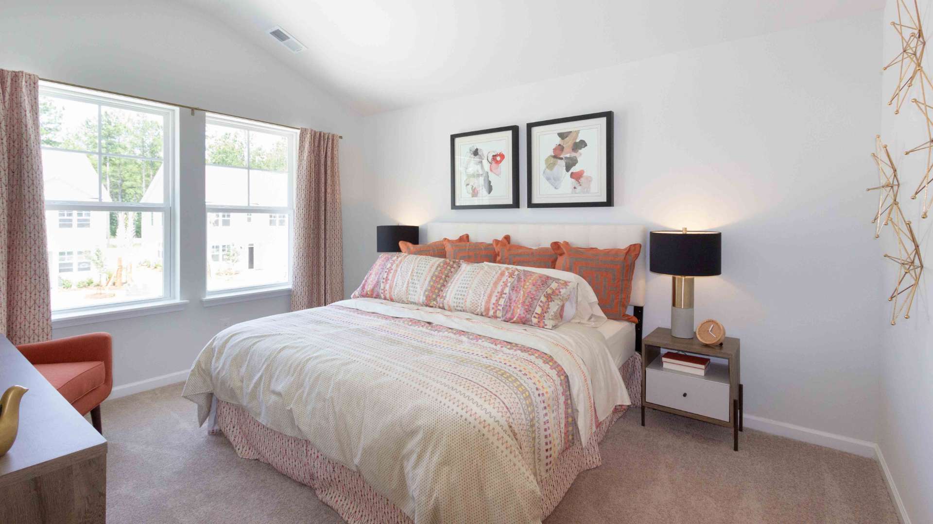 Primary Bedroom featuring a large bed, nightstands, lamps, and multiple windows