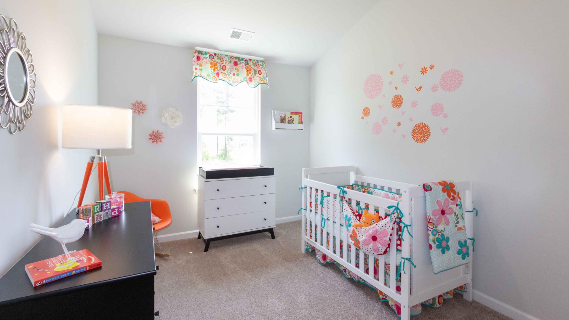 additional bedroom Nursery setup with crib, dresser, wall decals, and colorful decor
