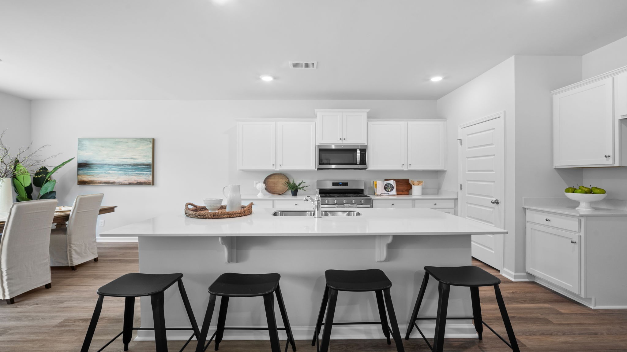 Gourmet kitchen featuring oversized island, stainless steel appliances, walk-in pantry, and abundant cabinetry.