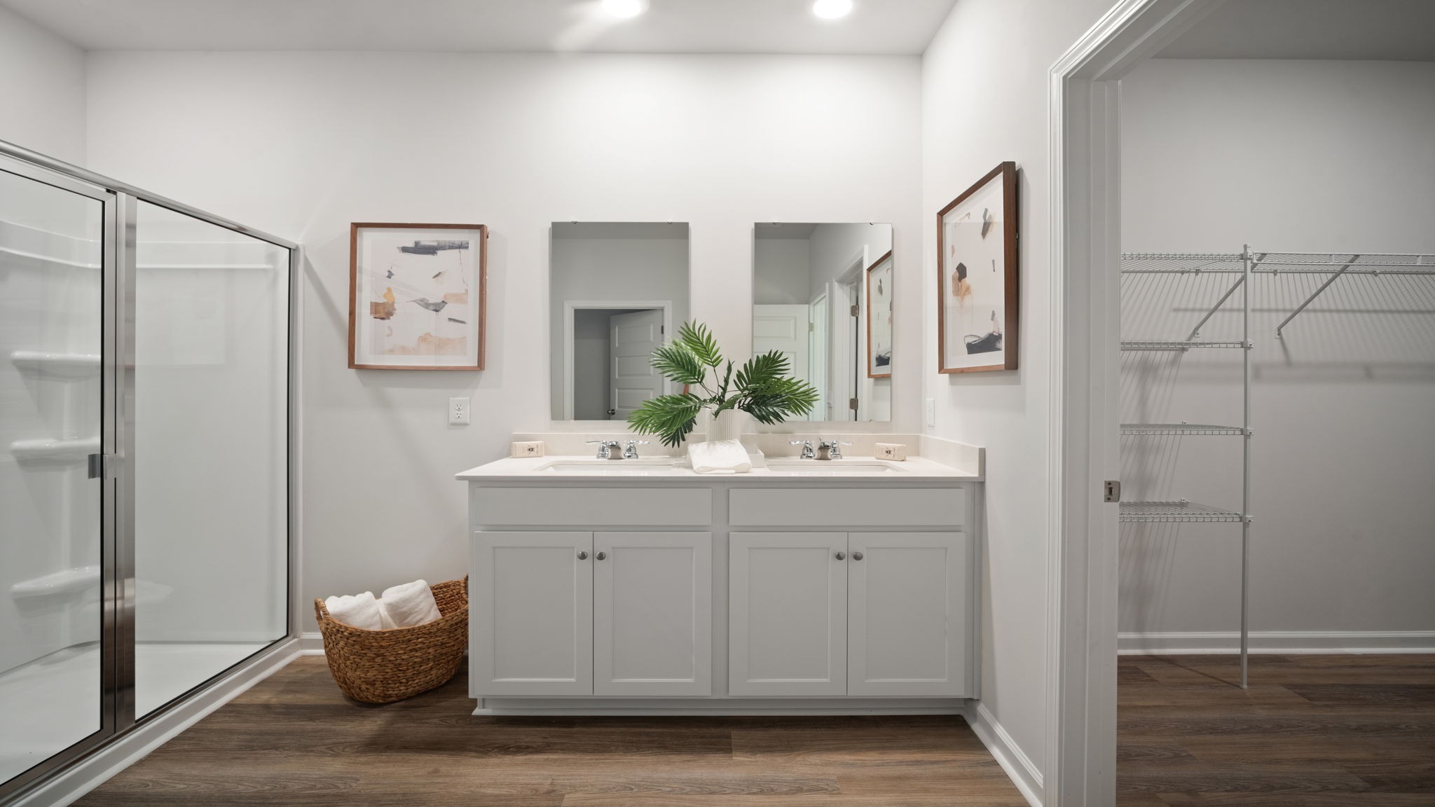 Spa-inspired primary bathroom with dual vanities, walk-in shower, and contemporary finishes.
