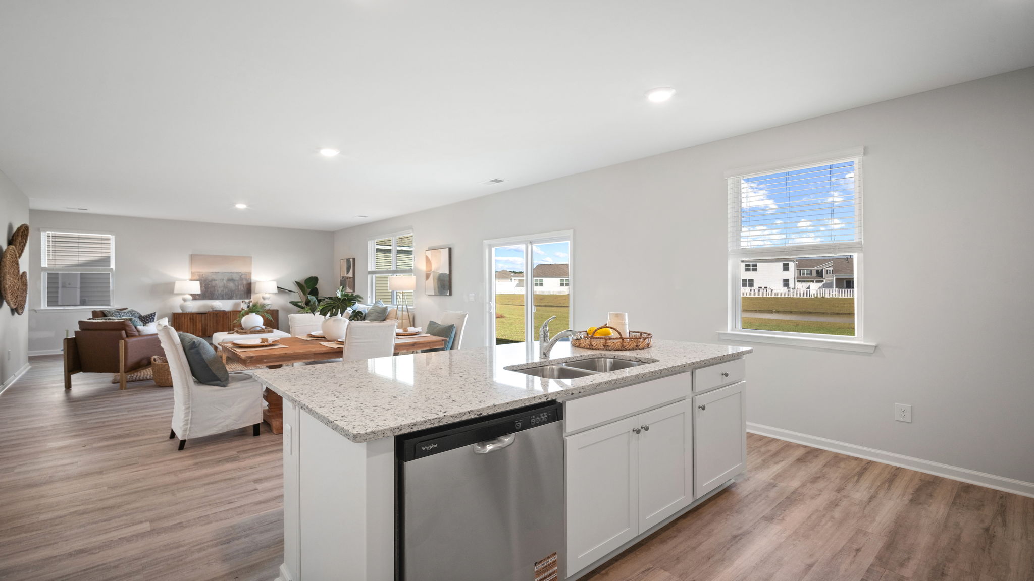 Open-concept kitchen in the Galen home plan with center island, stainless steel appliances, spacious cabinetry, and adjacent dining area.