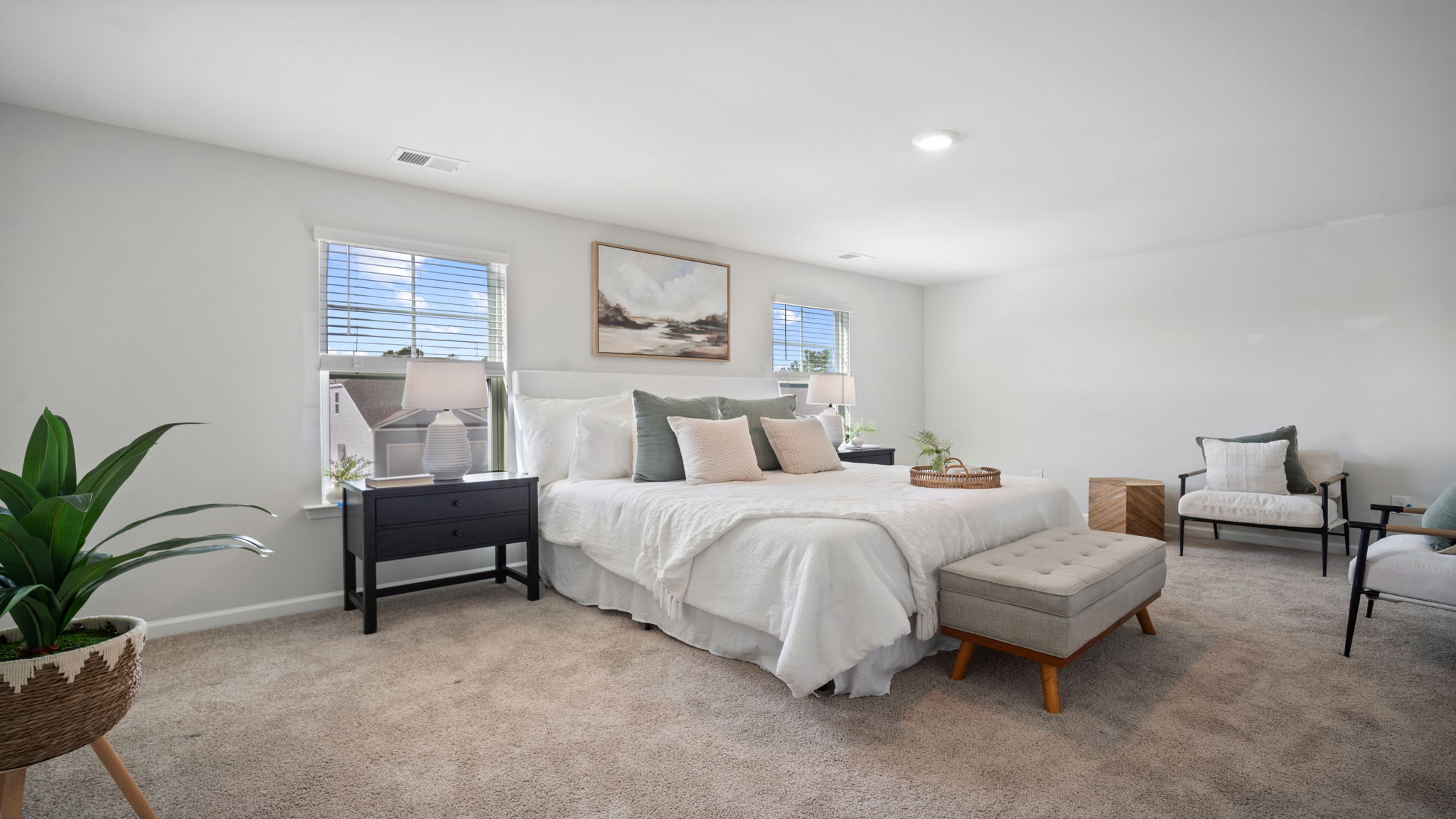 Primary bedroom with large windows and convenient access to ensuite bath.