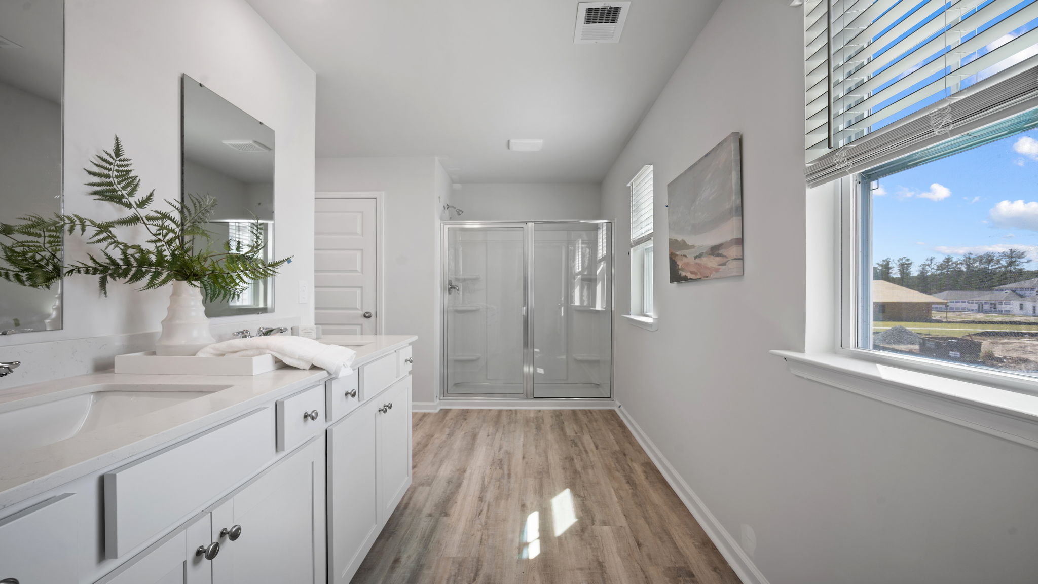 Luxurious primary bath featuring dual sinks and a spacious walk-in shower.
