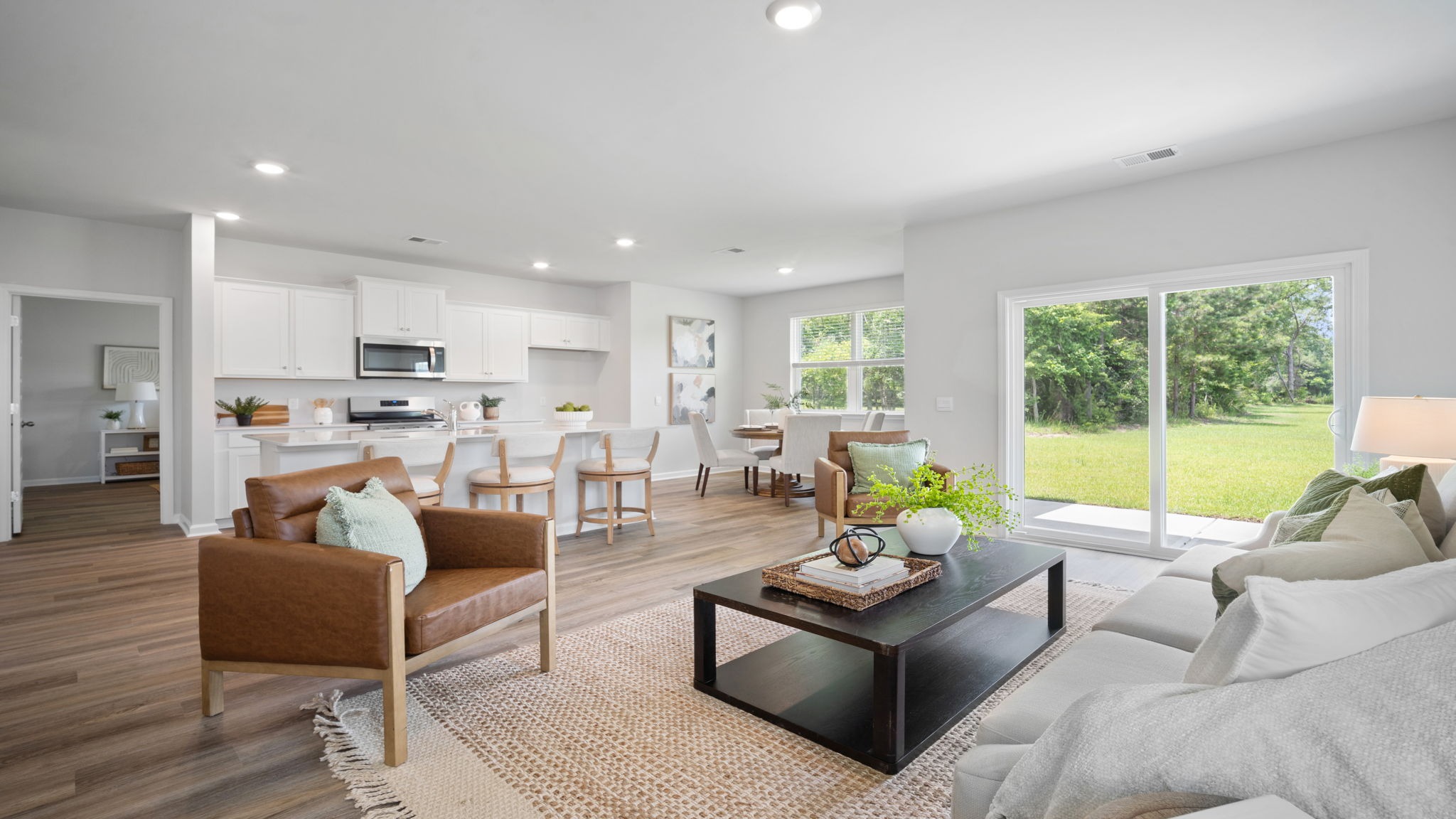Inviting family room with large windows, modern finishes, and seamless flow to the kitchen and dining room.