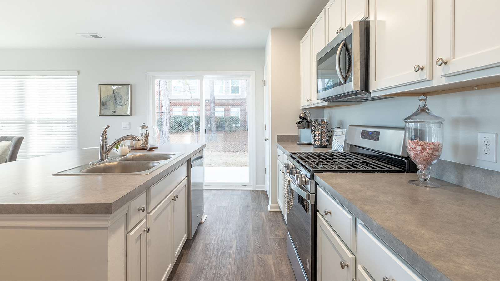 Chef-inspired kitchen in the Duncan floorplan at The Towns at Blue Jay offering a spacious center island, contemporary cabinetry, modern appliances, and open sightlines to the main living spaces.