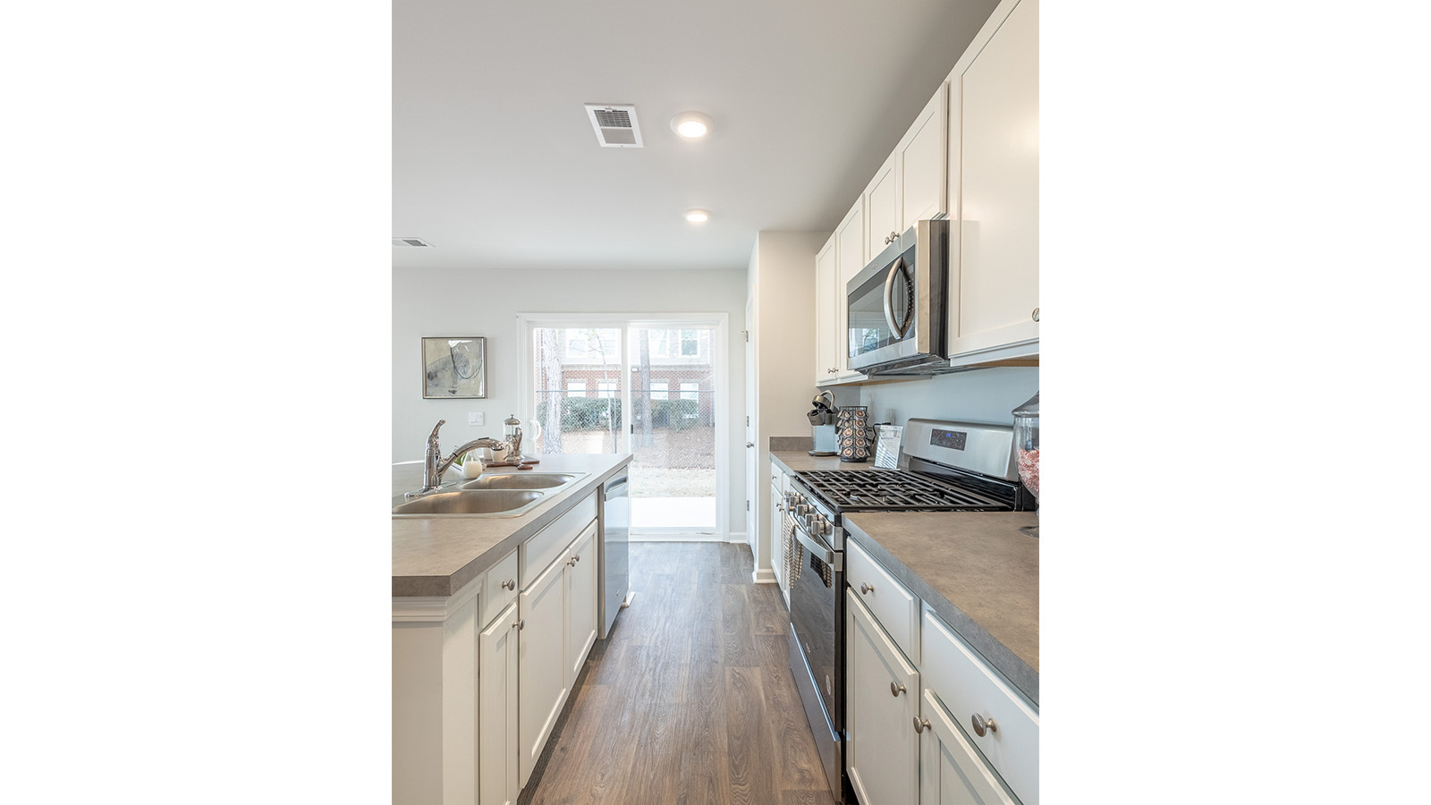 Open-concept kitchen in the Duncan floorplan by D.R. Horton at The Towns at Blue Jay featuring a spacious center island, modern cabinetry, stainless steel appliances, ample counter space, and seamless flow to the dining and living areas for effortless entertaining.