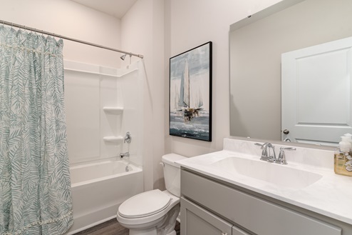 Dover Secondary bathroom with white cabinets and a shower tub combo