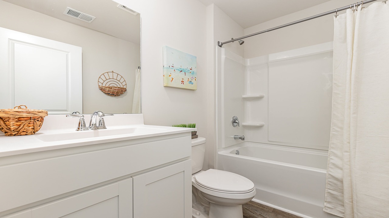 secondary bathroom with white cabinets